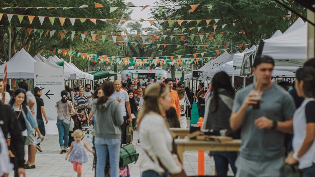 Drukbezocht outdoor event met kraampjes en bezoekers, passend bij personalisatie events