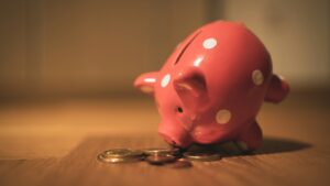 Een roze spaarvarken met munten, symbool voor sparen en financiële planning.