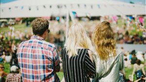 Bezoekers kijken naar festivalprogramma, voorbeeld van personalisatie events en doelgroepbeleving