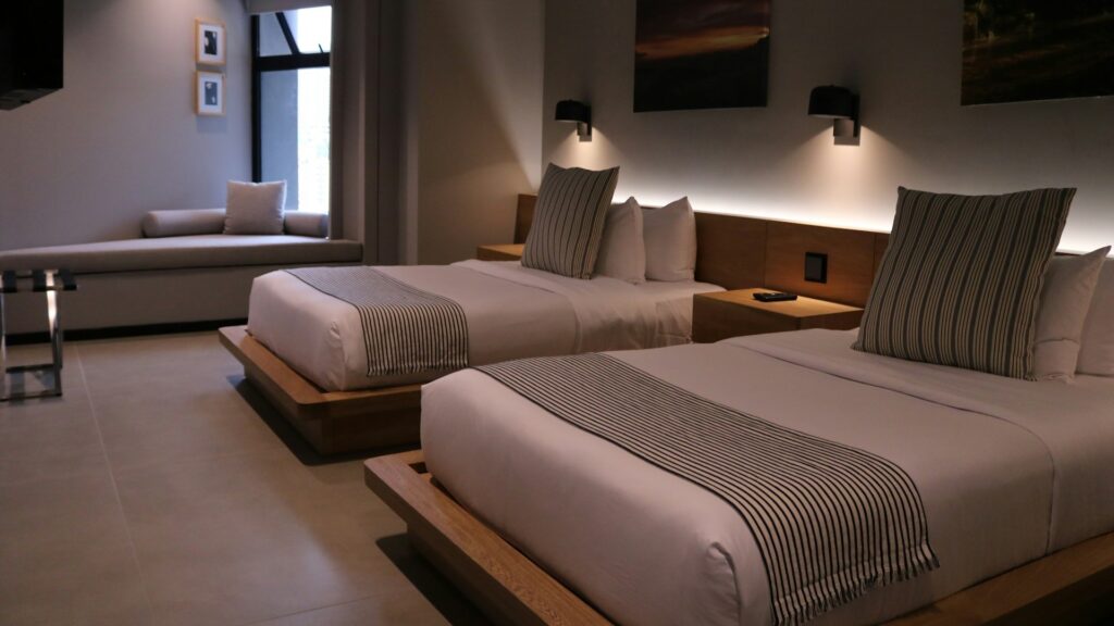 Moderne hotelkamer met twee bedden en warme verlichting als voorbeeld van hotelkamer inrichting