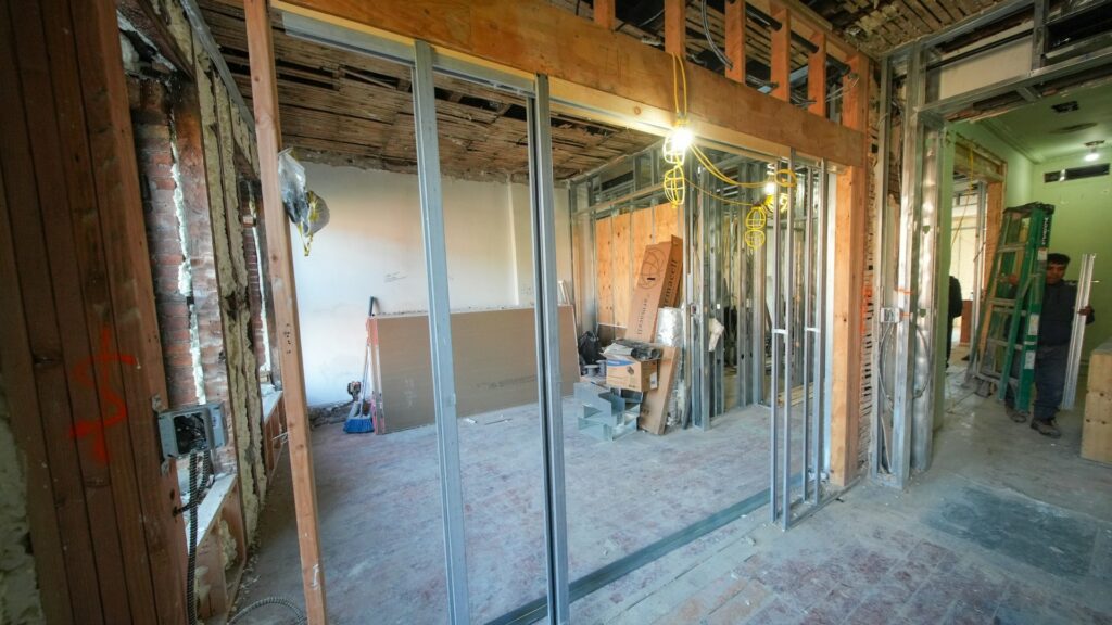 Ruwbouwfase bij bestaande woning verbouwen met open wanden, leidingen en constructiewerk zichtbaar