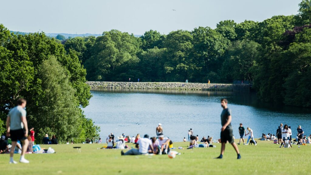 Mensen relaxen in een groen park aan het water terwijl ze een nieuwe stad verkennen
