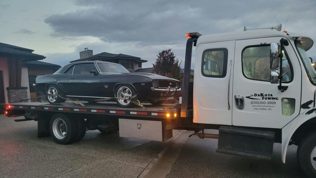 Autotransport groeit met transport van klassieke auto op takelwagen in woonwijk tijdens avonduren