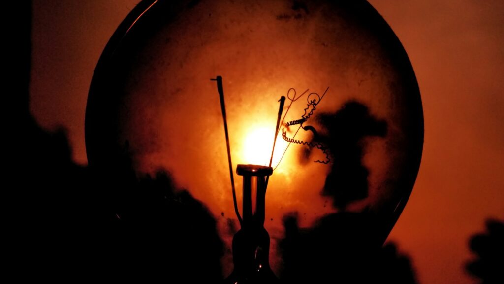 Gloeilamp met zichtbaar filament als symbool voor energieverbruik verlagen door efficiënte verlichting