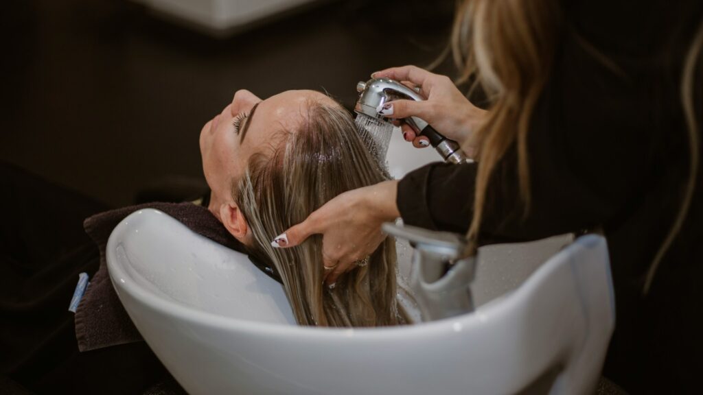 Haar wassen in kapsalon met aandacht voor verzorging om haar gezond houden tussen knipbeurten